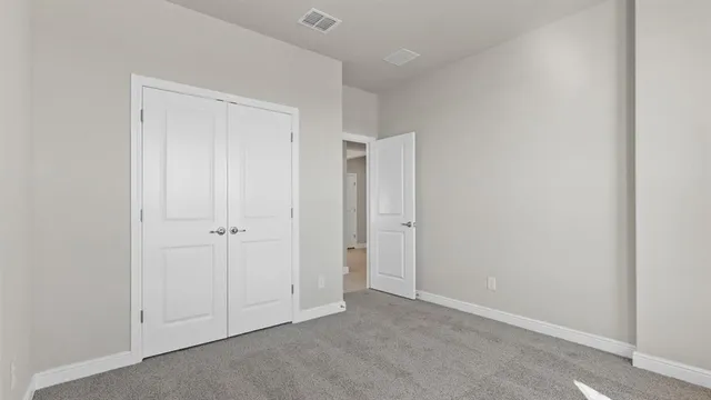 a view of a hallway with wooden floor and a bathroom