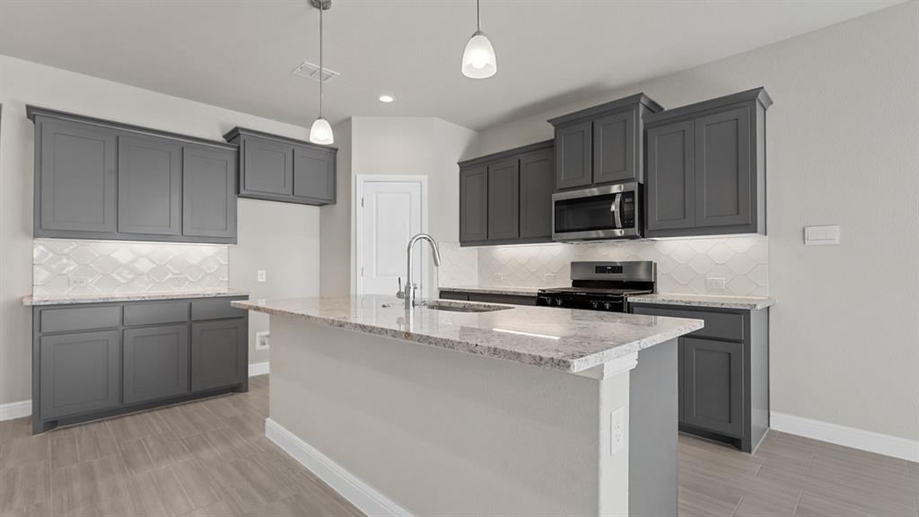 a kitchen with kitchen island granite countertop a sink stainless steel appliances and white cabinets