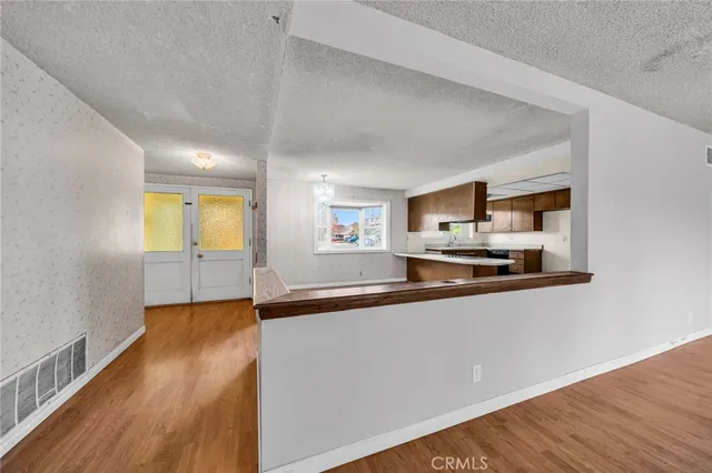 a view of a kitchen with wooden floor and a sink