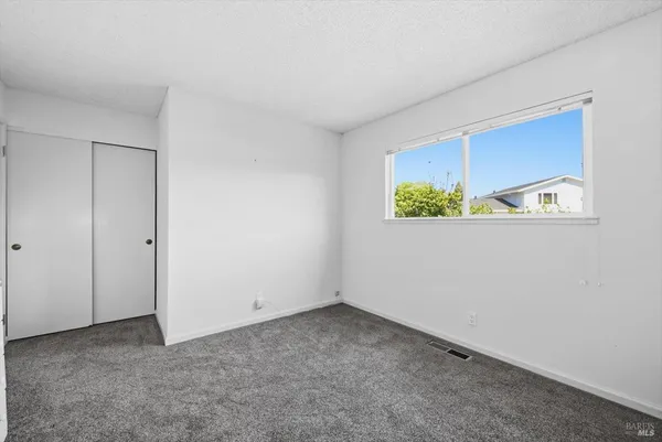a spacious bedroom with a bed and table