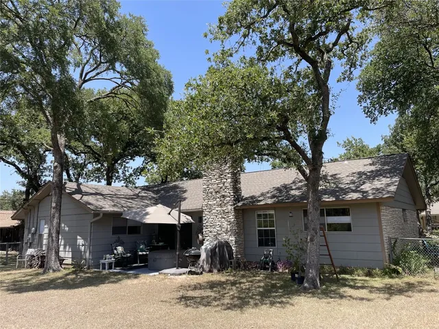 a front view of a house with a yard and tree s