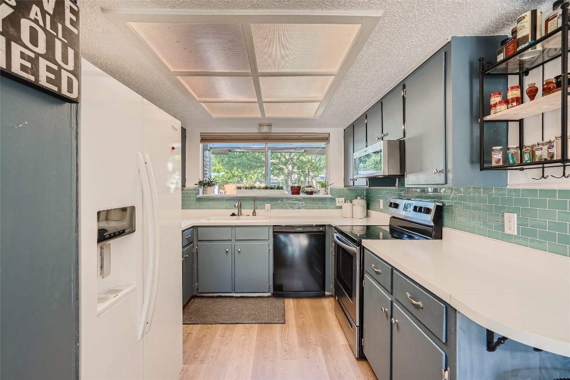 9206 Robins Nest Lane Austin, TX 78729 - Photo 6 of 18 a kitchen with a sink appliances cabinets and a large window