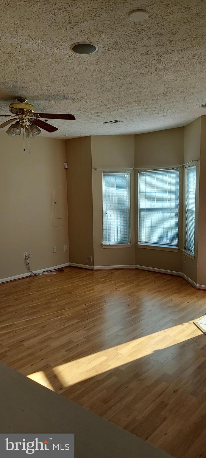 8089 Brookstone Court Severn, MD 21144 - Photo 15 of 33 an empty room with wooden floor and windows