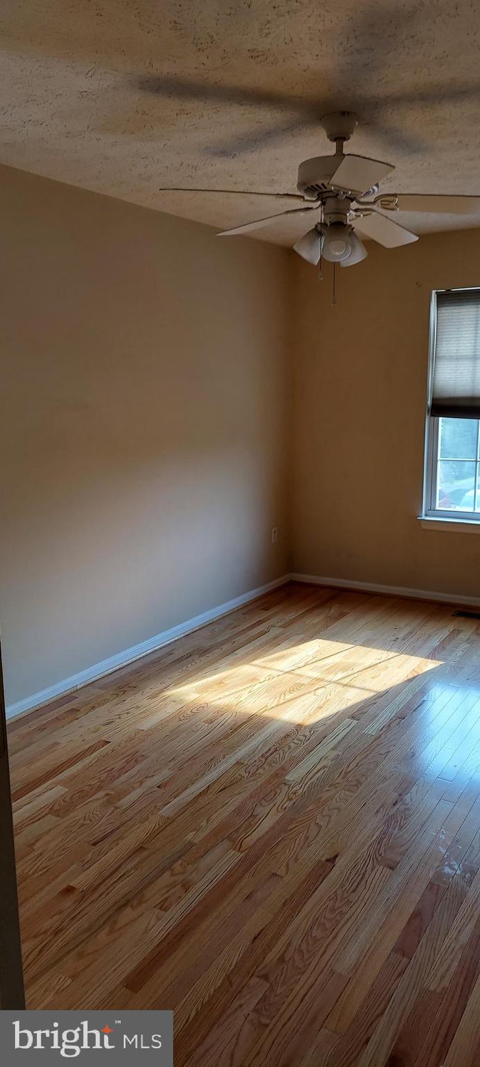 8089 Brookstone Court Severn, MD 21144 - Photo 20 of 33 a view of a room with wooden floor and fan
