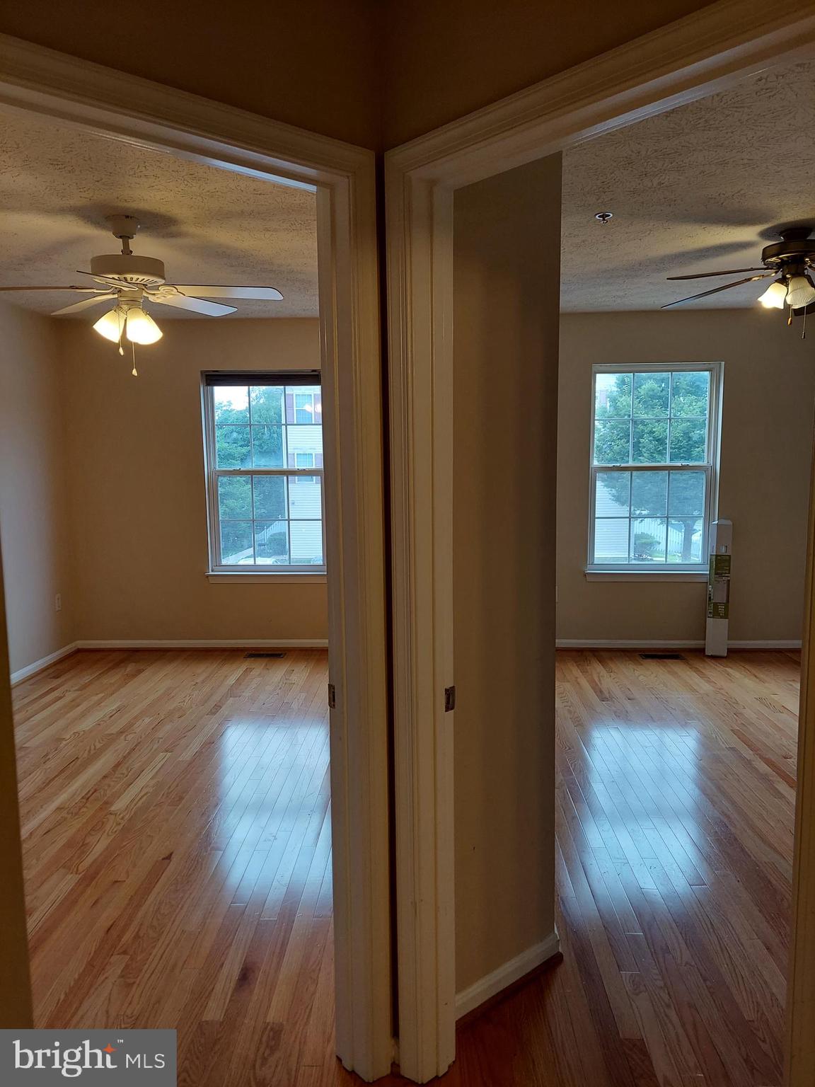 8089 Brookstone Court Severn, MD 21144 - Photo 22 of 33 a view of an empty room with wooden floor and a window