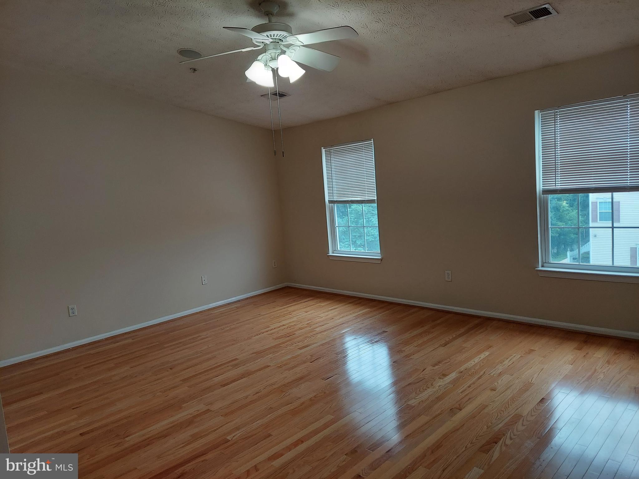 8089 Brookstone Court Severn, MD 21144 - Photo 28 of 33 a view of an empty room with wooden floor and a window