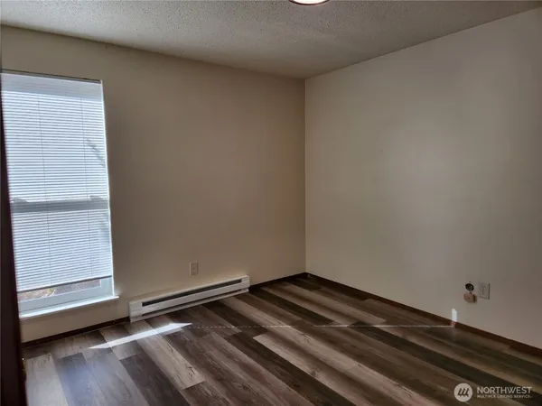 a view of a room with wooden floor and a window