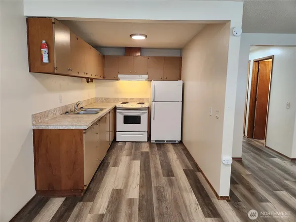 a kitchen with a sink a refrigerator and cabinets
