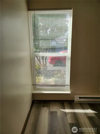 a view of a small space with wooden floor and a window