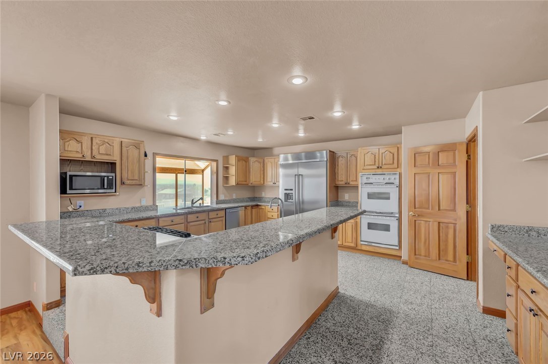 640 North Racetrack Road Henderson, NV 89015 - Photo 23 of 65 A chef's dream, this generously sized kitchen features sleek granite countertops and integrated modern appliances.
