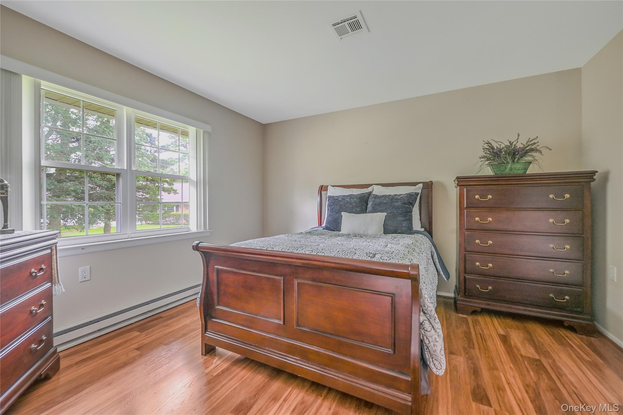 310 C Woodbridge Drive Ridge, NY 11961 - Photo 17 of 24 a bedroom with a bed and a window