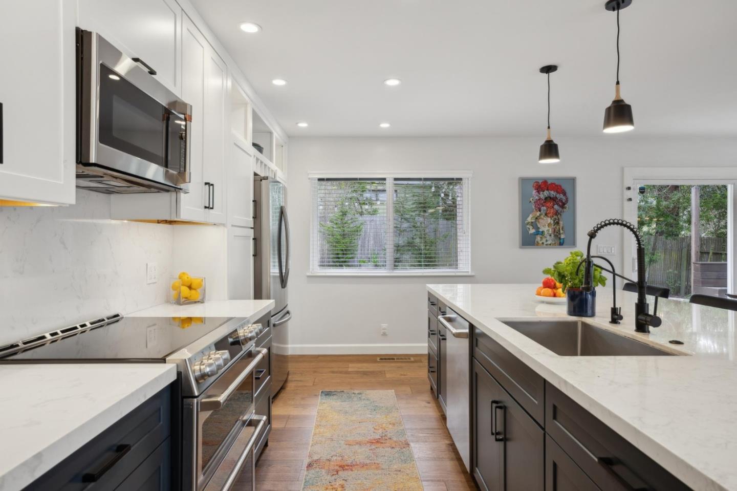 4095 Sunset Lane Pebble Beach, CA 93953 - Photo 14 of 55 a kitchen with stainless steel appliances a sink a stove and a wooden floors