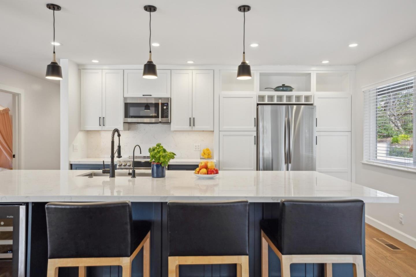4095 Sunset Lane Pebble Beach, CA 93953 - Photo 16 of 55 a kitchen with stainless steel appliances a dining table chairs refrigerator and microwave
