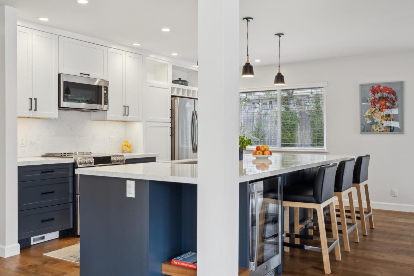 4095 Sunset Lane Pebble Beach, CA 93953 - Photo 10 of 55 a kitchen with stainless steel appliances kitchen island granite countertop a stove a sink a dining table and chairs with wooden floor
