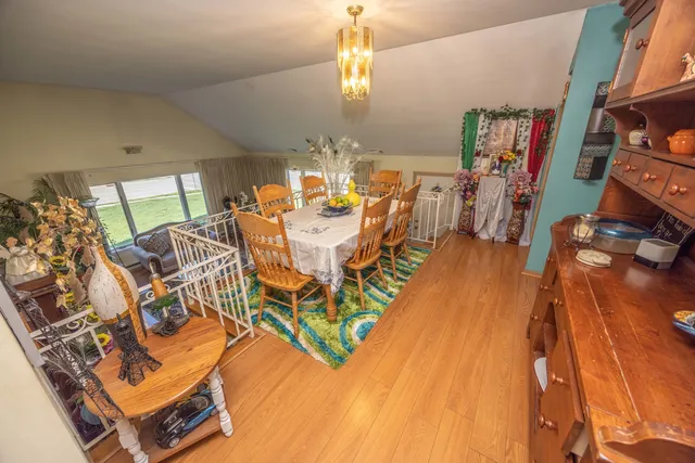 a view of a dining room with furniture a chandelier and wooden floor