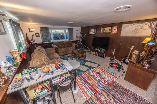 a living room with furniture a rug and a flat screen tv