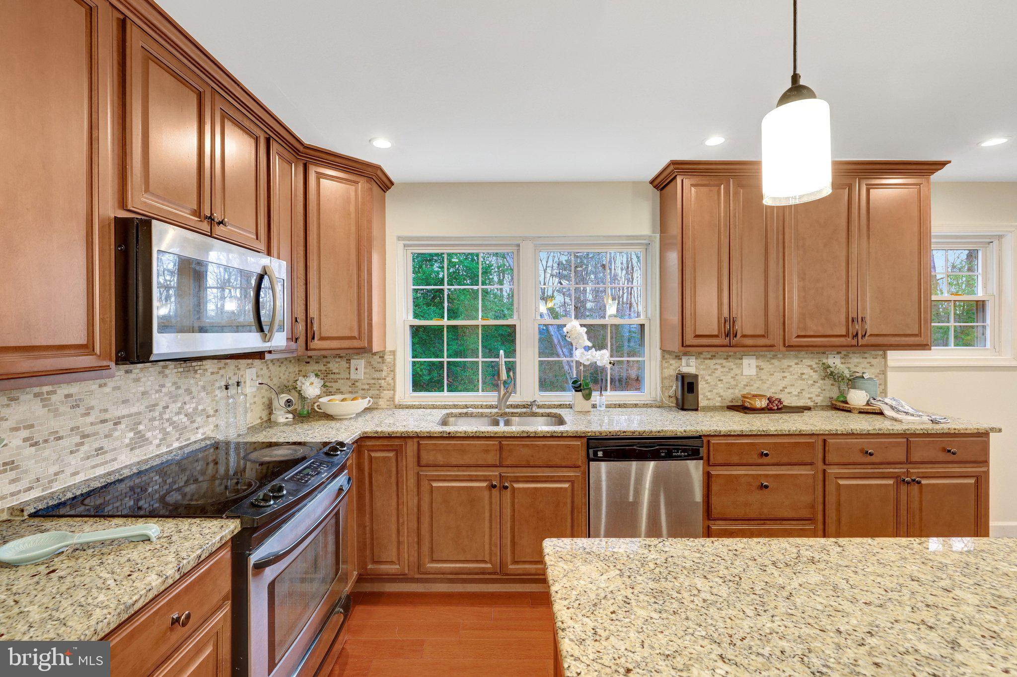 1827 Post Oak Trail Reston, VA 20191 - Photo 7 of 33 a kitchen with stainless steel appliances granite countertop a sink a stove and a wooden cabinets