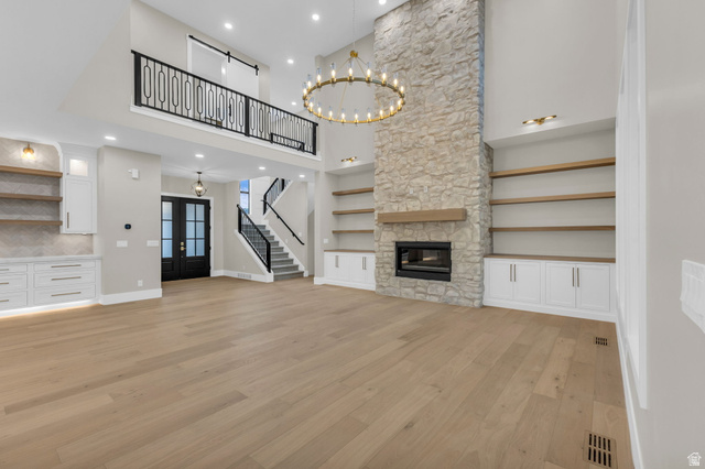 2828 Jojo Road Eagle Mountain, UT 84005 - Photo 9 of 63 Great room featuring a floor-to-ceiling stone fireplace with a wood mantel, integrated electric fireplace, and high ceilings