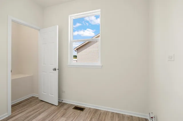 a view of a small space with wooden floor and a window