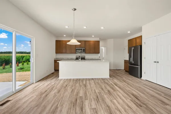 a view of kitchen with refrigerator microwave and wooden floor