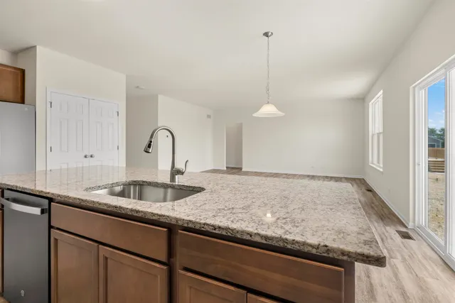 a kitchen with granite countertop a sink and a wooden floor