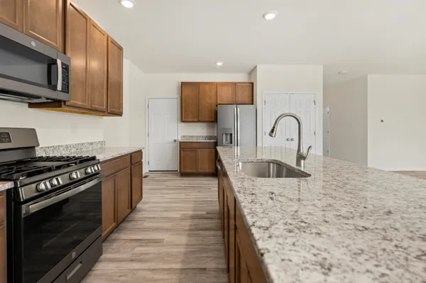 a kitchen with stainless steel appliances granite countertop a stove top oven a sink and dishwasher