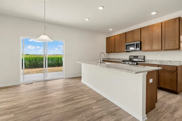 a kitchen with stainless steel appliances granite countertop a sink a microwave a refrigerator and a stove