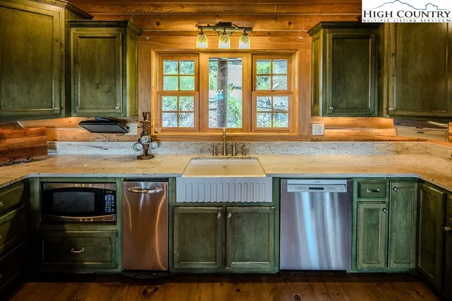 a kitchen with kitchen island granite countertop a sink cabinets and stainless steel appliances