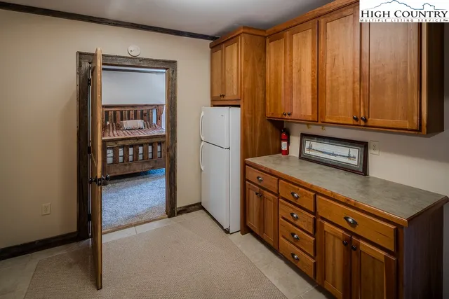 an aerial view of a house with yard and trees in the background