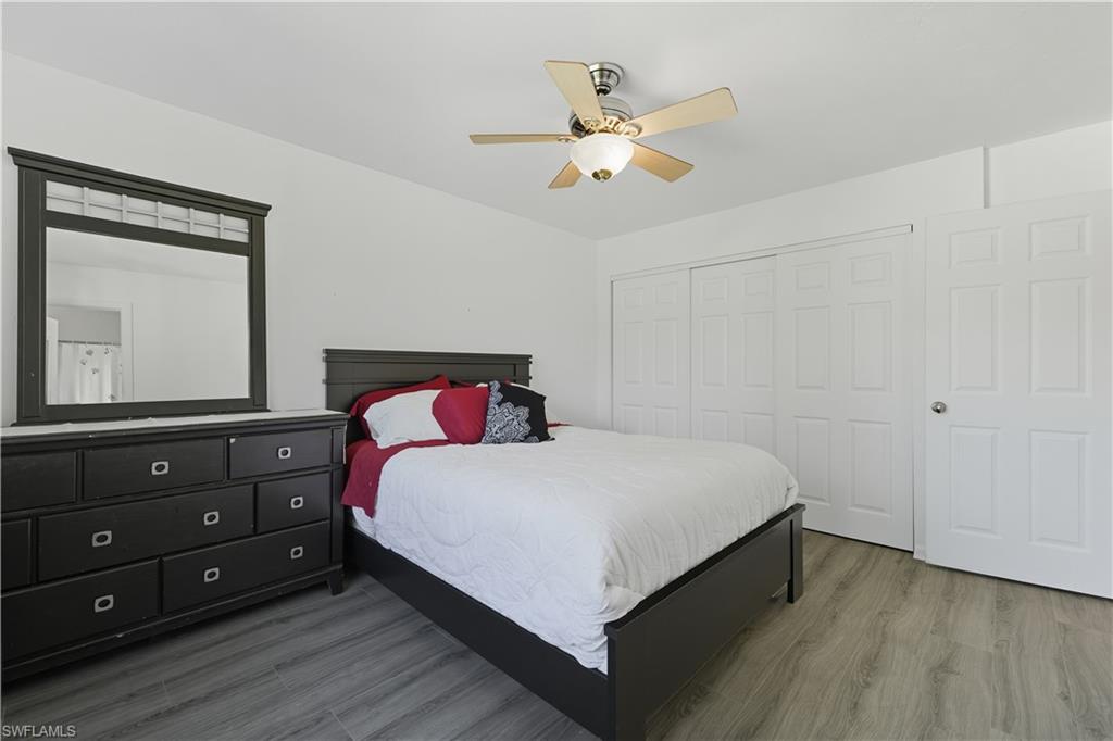 5356 16th Place Southwest, Unit G4 Naples, FL 34116 - Photo 12 of 23 a bedroom with a bed and a chandelier