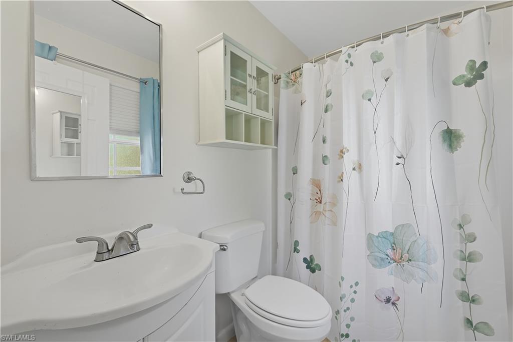5356 16th Place Southwest, Unit G4 Naples, FL 34116 - Photo 14 of 23 a bathroom with a sink a toilet and shower curtain