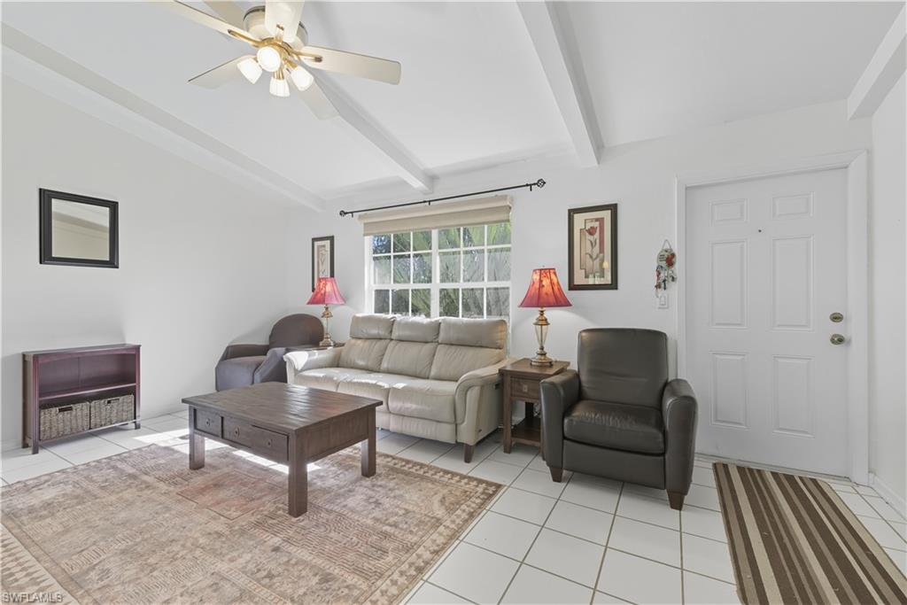 5356 16th Place Southwest, Unit G4 Naples, FL 34116 - Photo 4 of 23 a living room with furniture and a chandelier