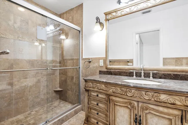 a bathroom with a granite countertop sink mirror and shower