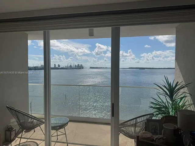 a view of a glass door with a balcony from a window