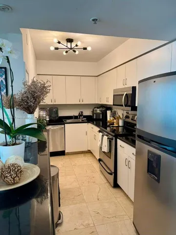 a kitchen with stainless steel appliances kitchen island granite countertop a sink and cabinets