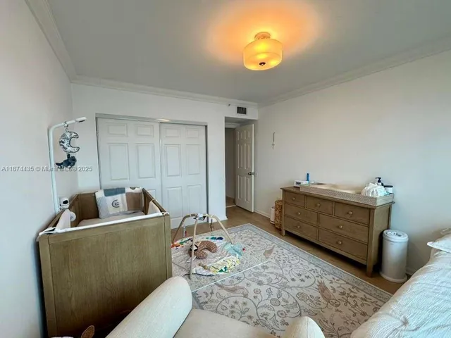 a living room with furniture and a baby crib