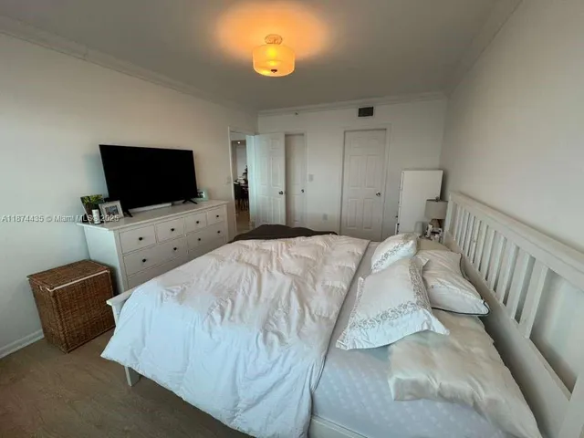 a bedroom with a bed and a flat screen tv