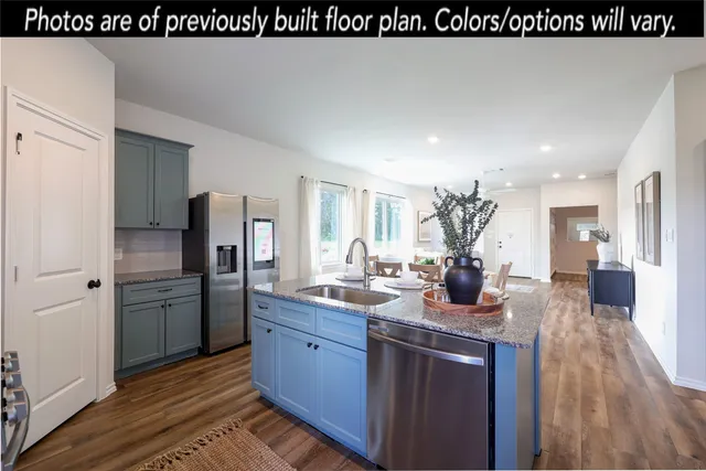 a kitchen with stainless steel appliances kitchen island granite countertop a sink a microwave cabinets and chairs