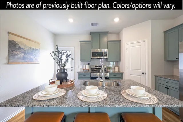 a kitchen with sink a microwave and cabinets