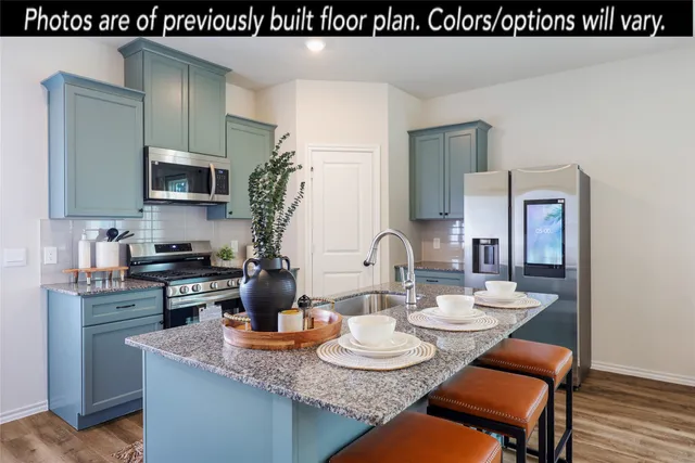 a kitchen with a sink a table and chairs in it