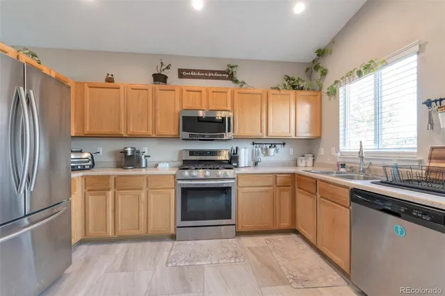 a kitchen with stainless steel appliances granite countertop a refrigerator sink and microwave