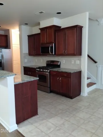 a view of a room with wooden floor and a fireplace