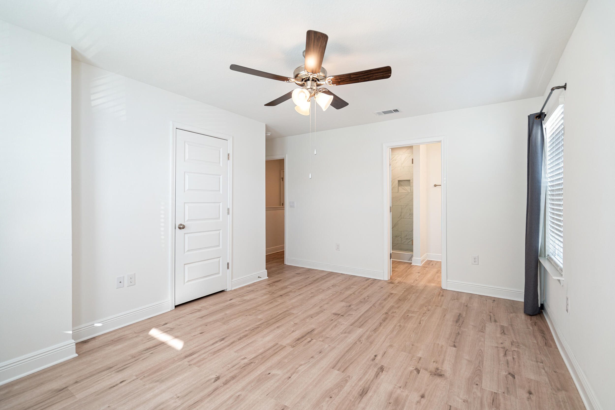 38 Redbird Loop Destin, FL 32541 - Photo 11 of 23 an empty room with wooden floor a ceiling fan and closet