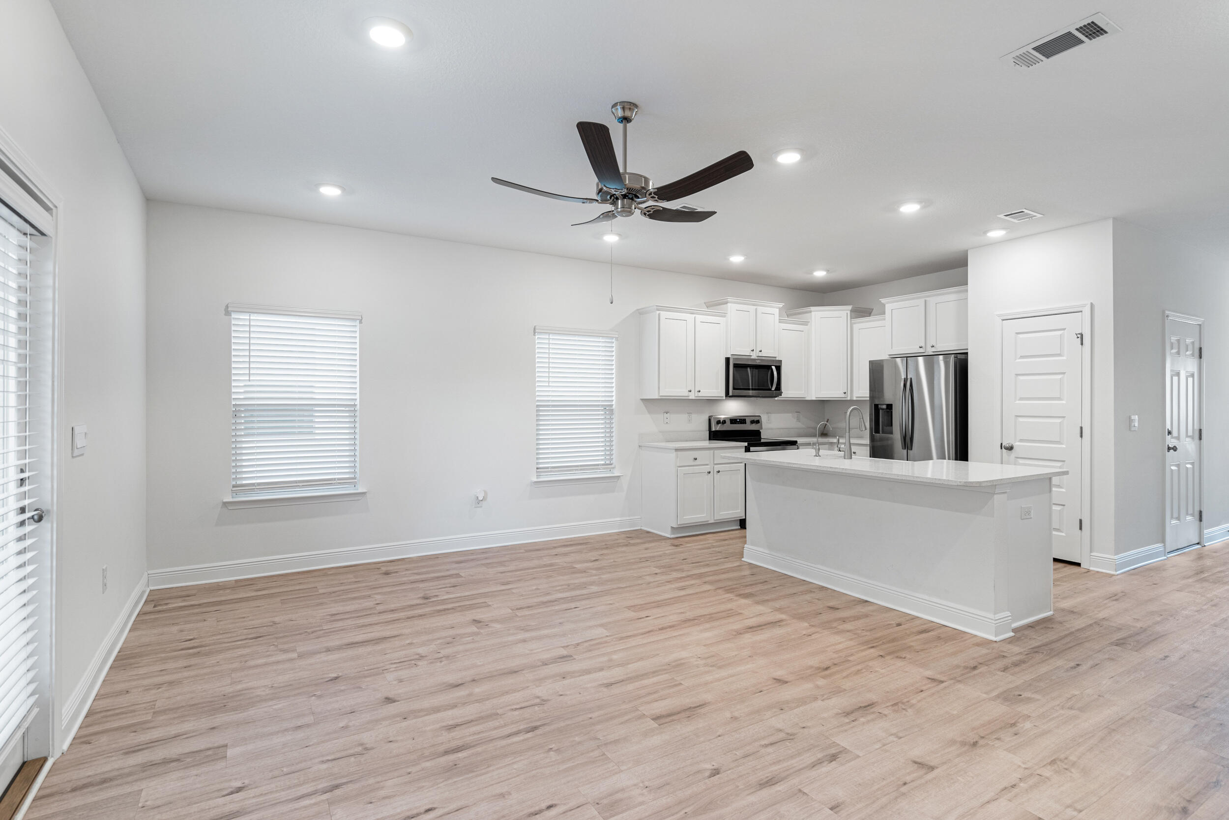 38 Redbird Loop Destin, FL 32541 - Photo 7 of 23 a view of kitchen with microwave a refrigerator and white cabinets with wooden floor