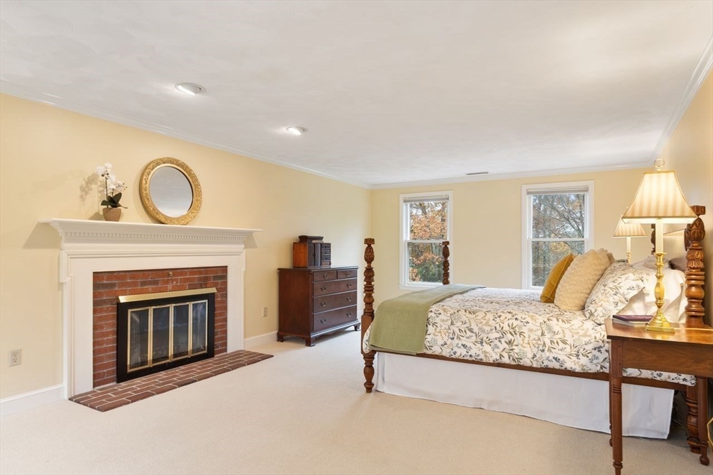 50 Hidden Road Andover, MA 01810 - Photo 19 of 42 a bedroom with a bed and a fireplace