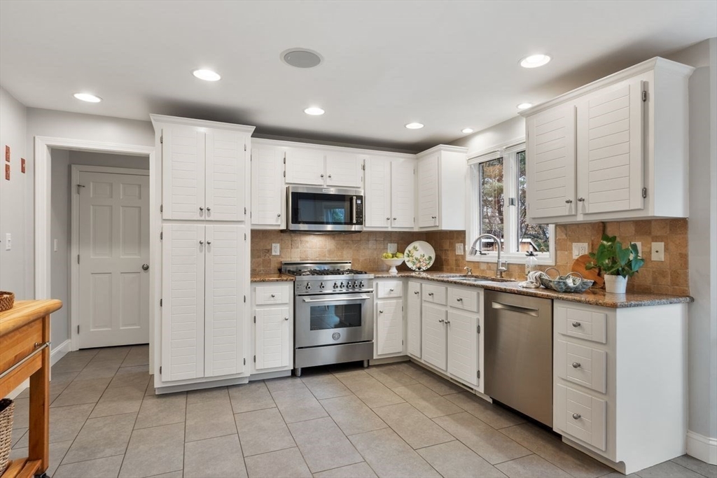 50 Hidden Road Andover, MA 01810 - Photo 7 of 42 a kitchen with white cabinets stainless steel appliances and a sink