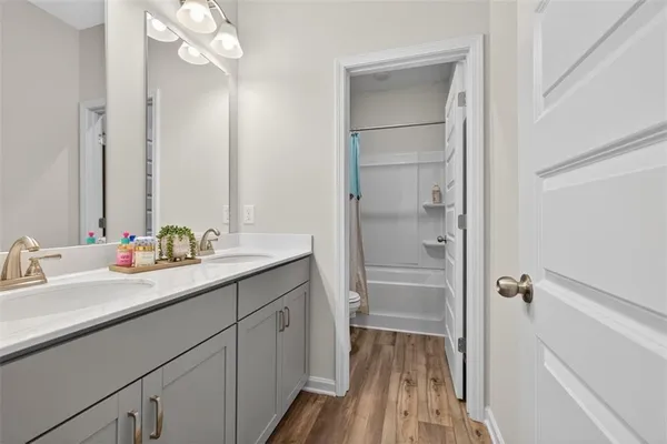 a bathroom with a double vanity sink a mirror and a shower