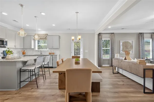 a view of a a dining room with furniture window and wooden floor