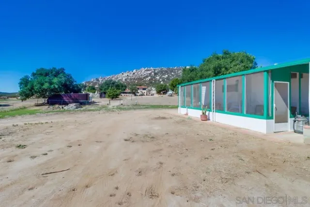 a view of a house with backyard and wooden fence