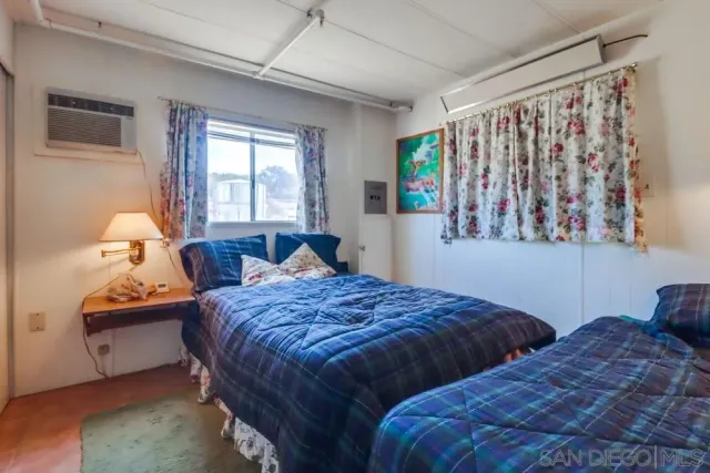 a bedroom with two beds and painting on the wall